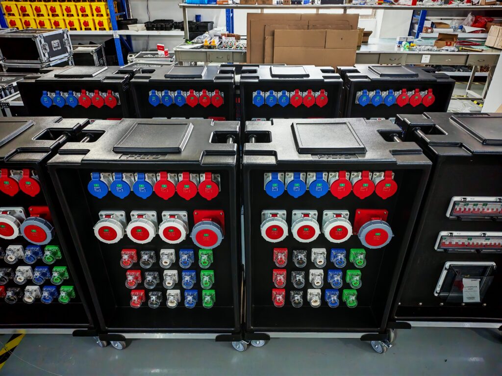 Schwarze Stromverteilerkästen mit roten und blauen Industriesteckdosen für Bühnen- und Beleuchtungstechnik